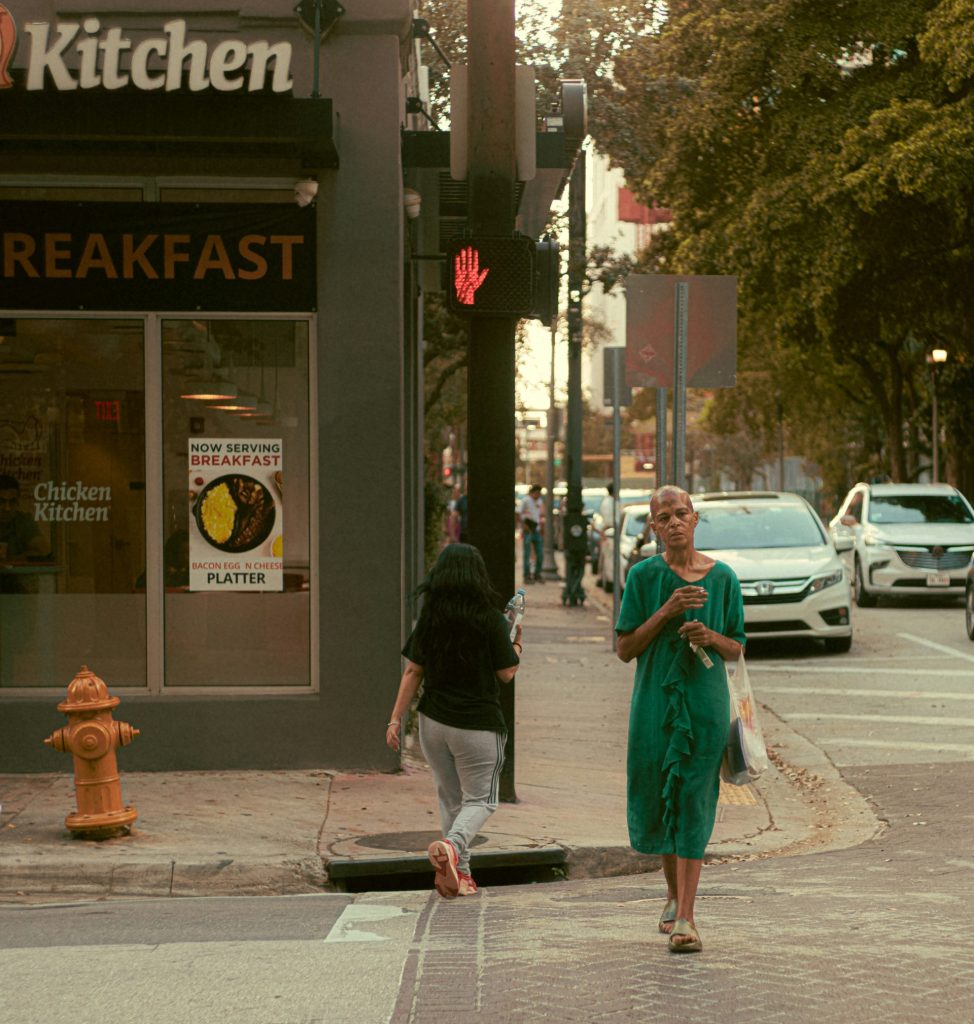 A woman in a green dress crossing the street